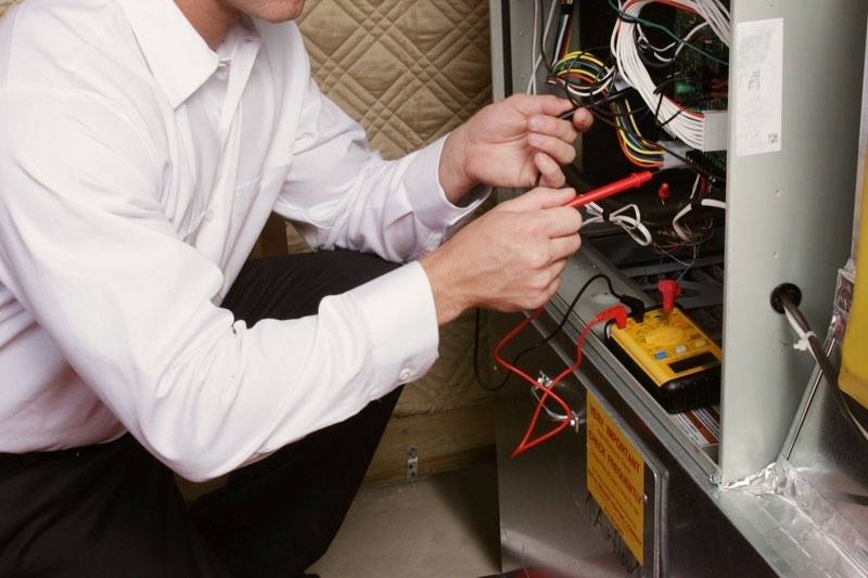 Close view of technician performing repairs on a furnace.
