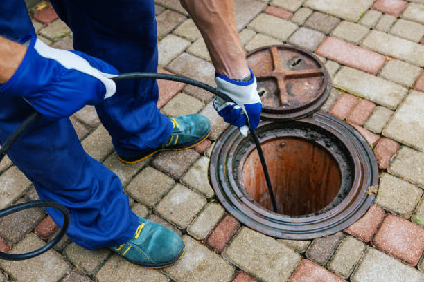 Technician conducting sewer line inspection through access point in brick patio in Downingtown, PA