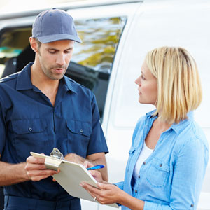 HVAC technician speaking with homeowner next to a white service truck.