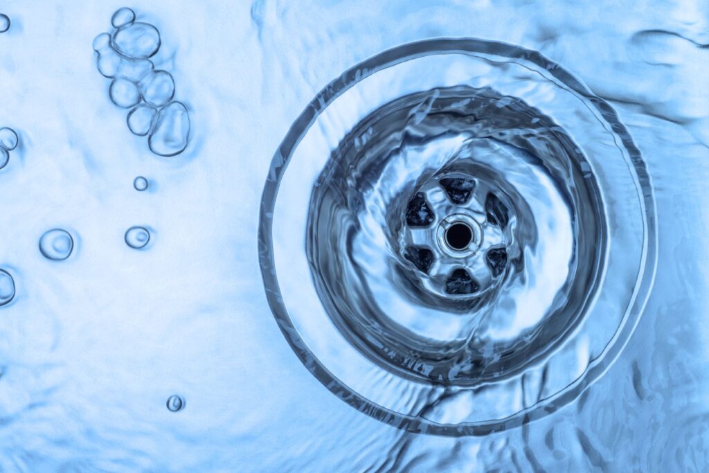 Close-up of a water flowing down a kitchen sink drain.